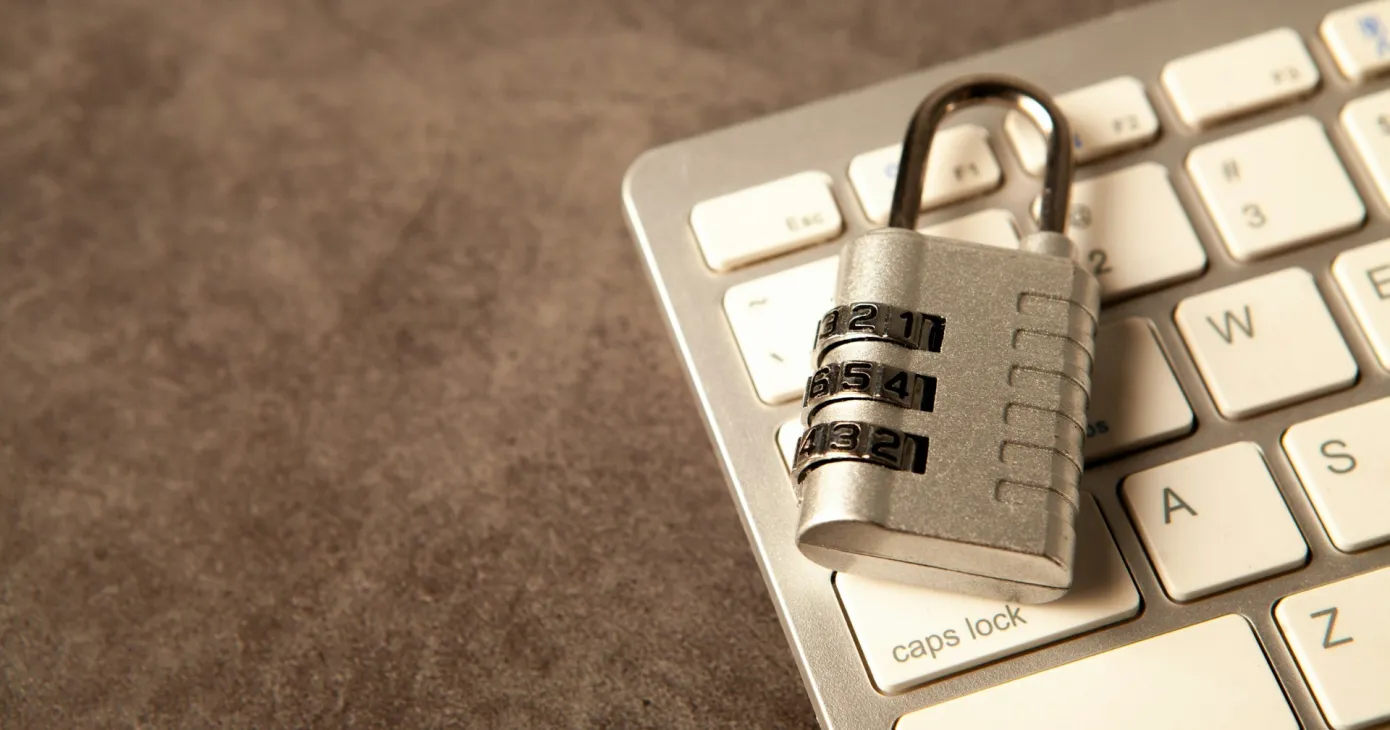 Un cadenas à combinaison posé sur un clavier d’ordinateur.